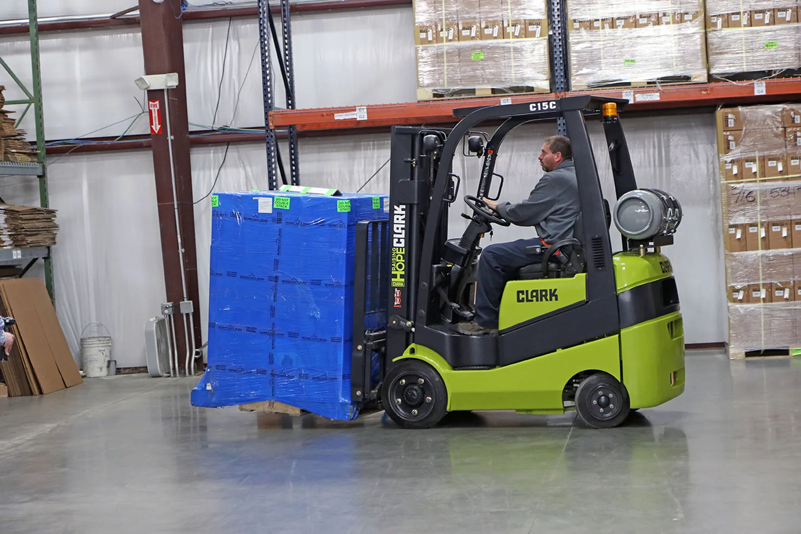 Forklift carrying a wrapped pallet past pallet racking in a Lehigh Valley warehouse